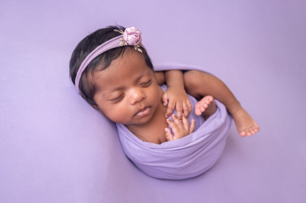 newborn photography session with baby girl in purple