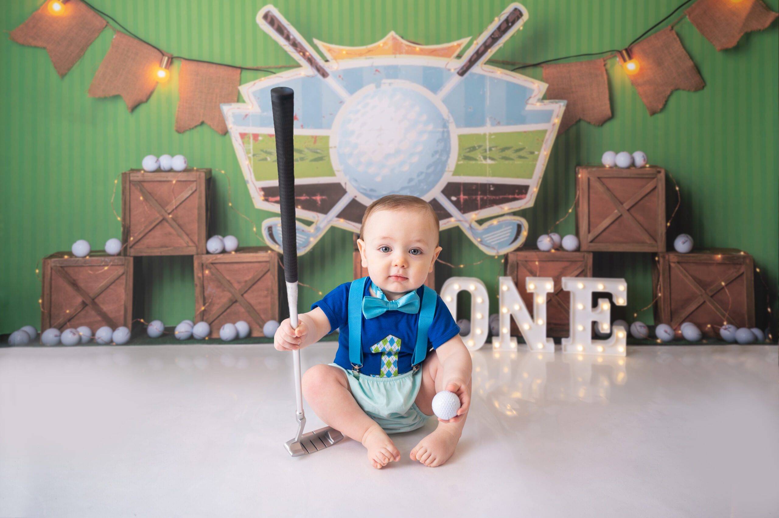one year old dressed in golf attire celebrating his first birthday