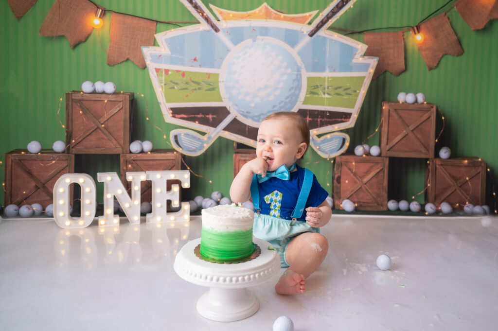 baby licking fingers during cake smash photo session