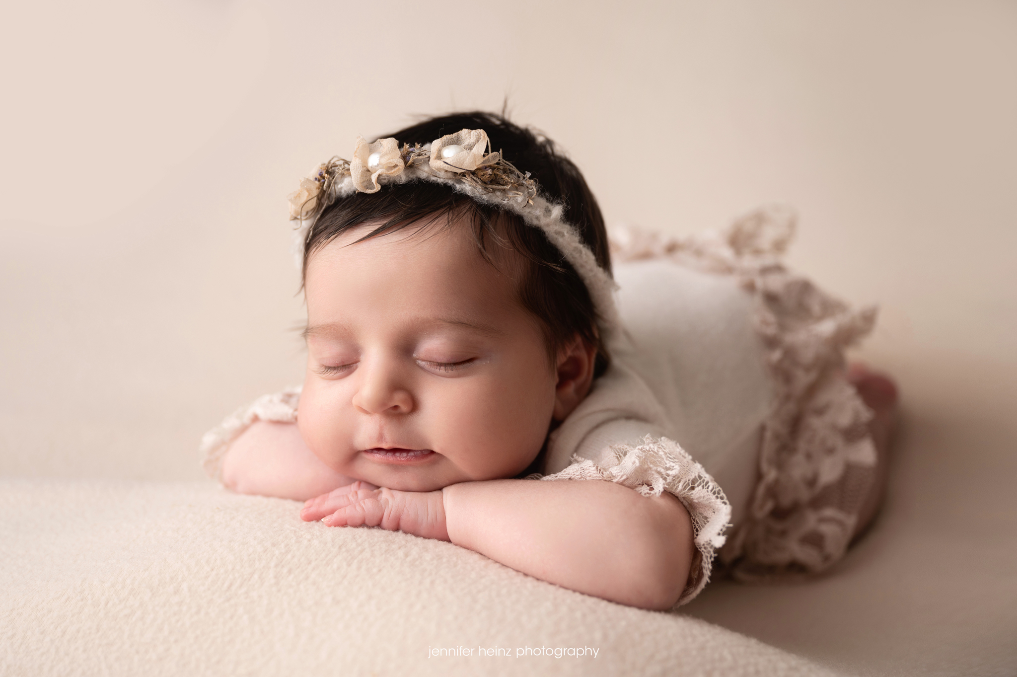 newborn baby girl in neutral outfit and floral headband